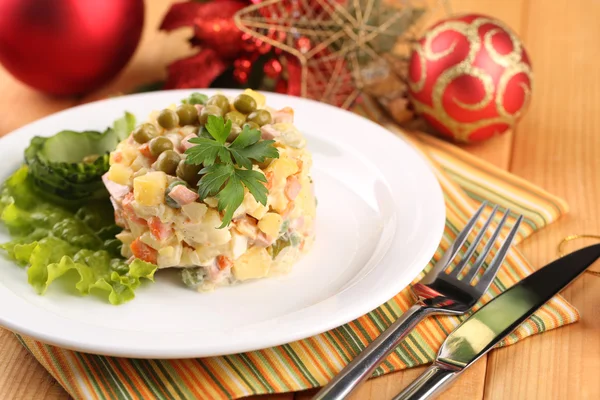 Geleneksel Rus salatası olivier, üzerinde parlak zemin üzerine ahşap masa üzerinde renkli peçete — Stok fotoğraf