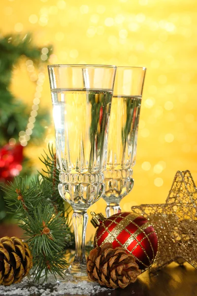 Composition with Christmas decorations and two champagne glasses, on bright background — Stock Photo, Image