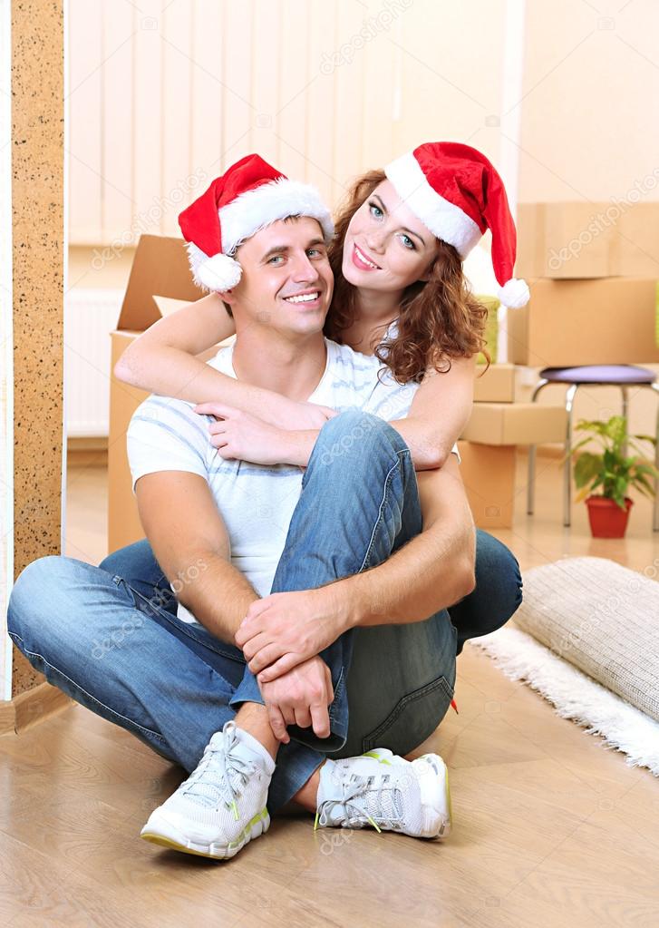 Young couple with boxes in new home celebrating New Years