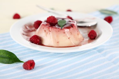 Panna cotta ahşap zemin üzerinde frambuaz sos ile
