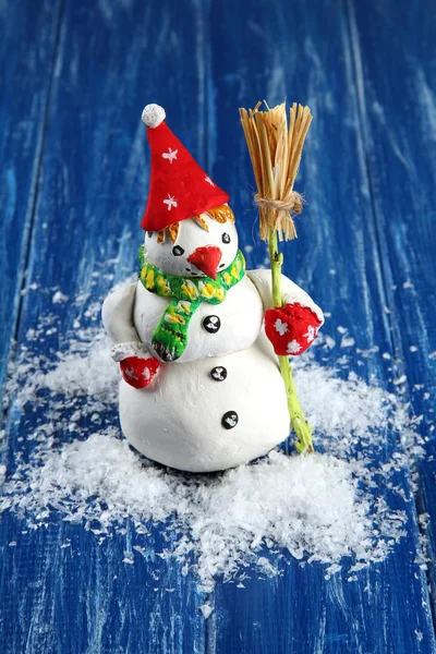 Bonito boneco de neve no fundo de madeira azul — Fotografia de Stock