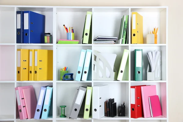 Prateleiras de escritório branco com pastas e artigos de papelaria diferentes, close-up — Fotografia de Stock