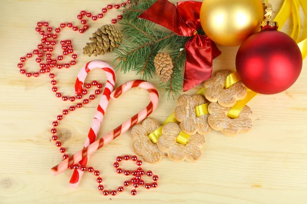 Biscotti su nastri con decorazioni natalizie su tavola di legno — Foto Stock