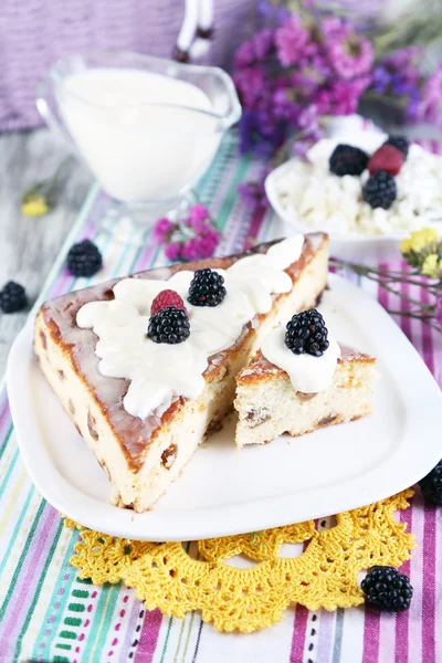 Cheese casserole with raisins on plate on napkin on wooden table close-up — Stock Photo, Image