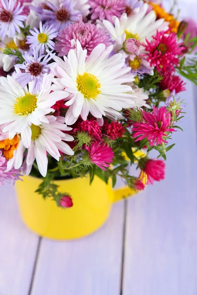 Blommor i mugg på träbord — Stockfoto