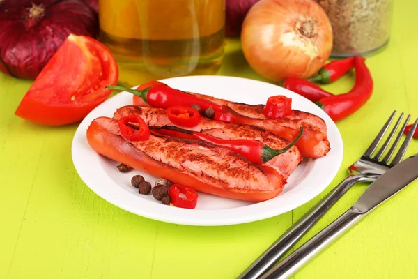 Deliciosas salchichas con verduras en plato sobre mesa de madera de cerca — Foto de Stock