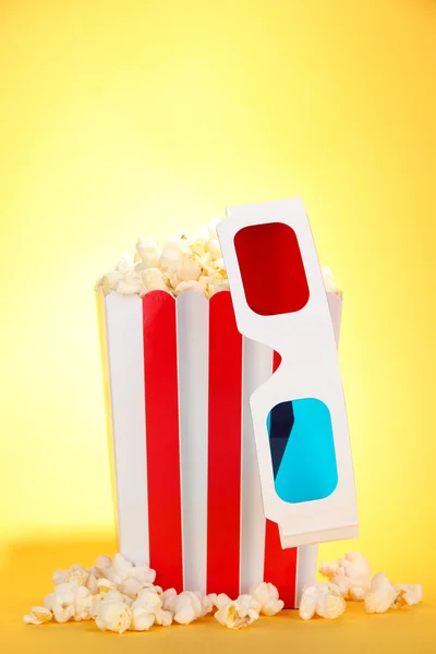 Popcorn et lunettes 3D sur fond jaune — Photo