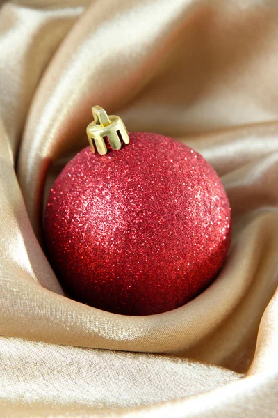 Beautiful Christmas ball on golden satin cloth — Stock Photo, Image