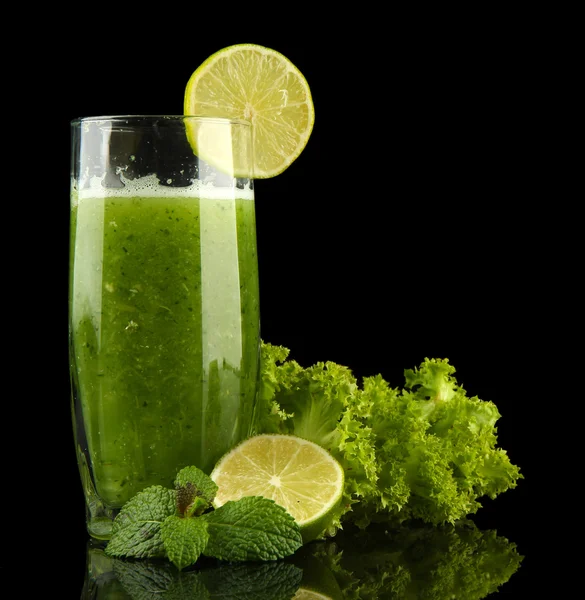 緑の野菜ジュースと黒に分離されたライムのガラス — ストック写真