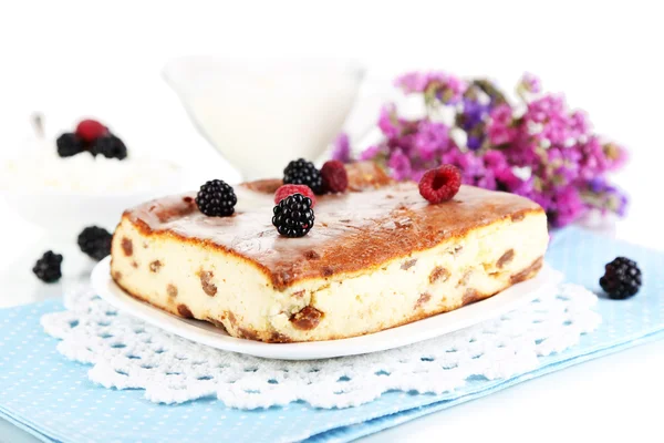 Cheese casserole with raisins on plate on napkin isolated on white — Stock Photo, Image