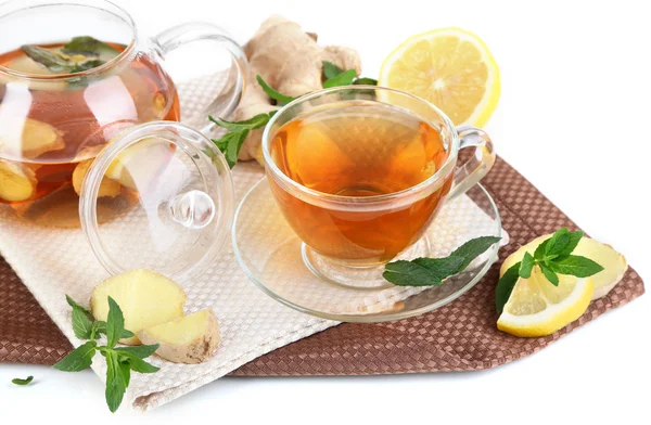 Bollitore e tazza di tè con zenzero su tovagliolo isolato su bianco — Foto Stock
