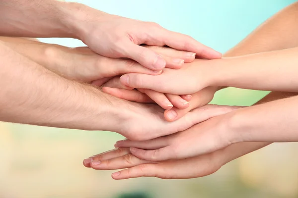 Mani unite su sfondo luminoso. Foto concettuale del lavoro di squadra — Foto Stock