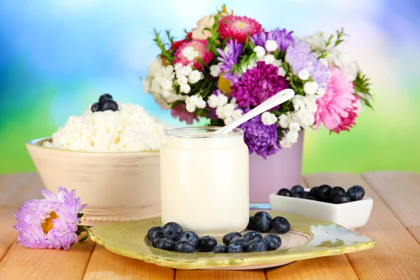 Frische Milchprodukte mit Blaubeeren auf Holztisch in Großaufnahme — Stockfoto