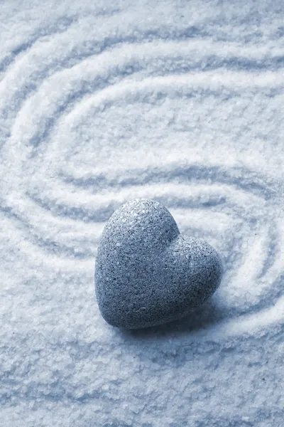 Grey zen stone in shape of heart, on sand background — Stock Photo, Image