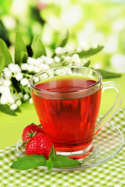 तेजस्वी पार्श्वभूमीवर टेबलवर स्वादिष्ट स्ट्रॉबेरी चहा — स्टॉक फोटो, इमेज