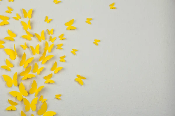 Paper yellow butterflies fly on wall in different directions — Stock Photo, Image