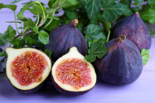 Ripe figs in leaves on wooden table close-up — Stock Photo, Image