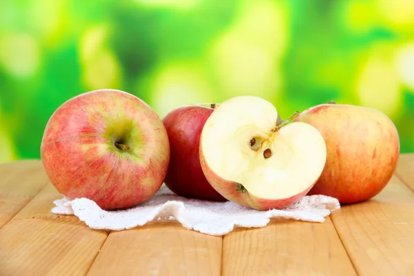 Ripe apples on wooden table, on bright background — Stock Photo, Image