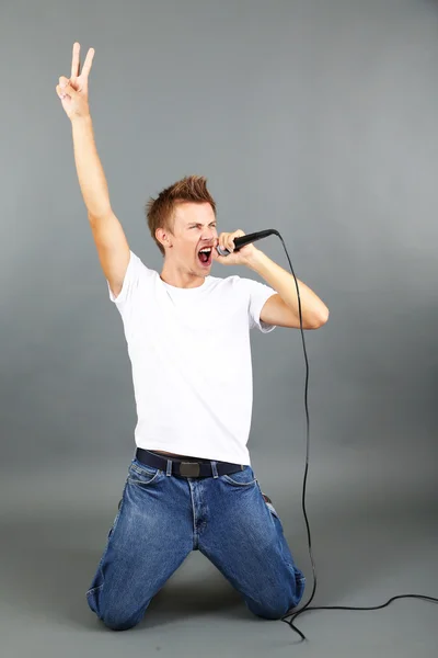 Jovem bonito canta — Fotografia de Stock