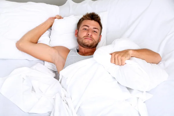 Bonito jovem homem na cama — Fotografia de Stock