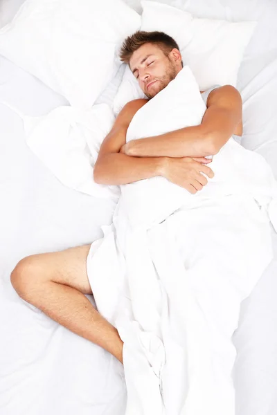 Schöner junger Mann im Bett — Stockfoto