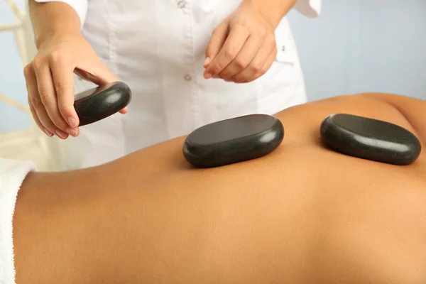 Young man having stone massage in spa salon — Stock Photo, Image