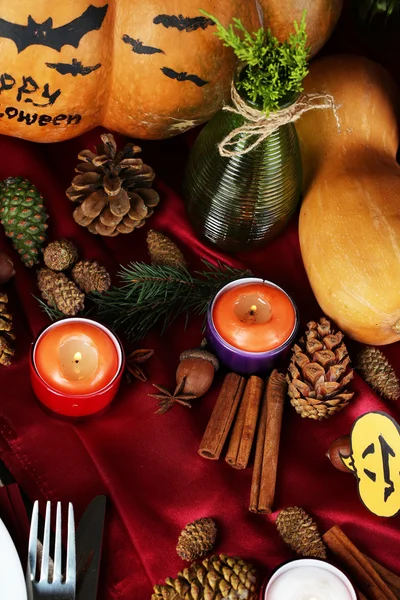 De instelling van de tabel voor halloween met pompoen en kaarsen close-up — Stockfoto