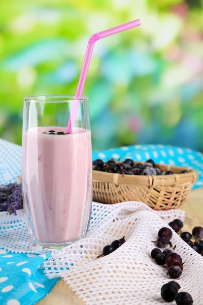 Вкусный молочный коктейль с ежевикой на деревянном столе на естественном фоне — стоковое фото