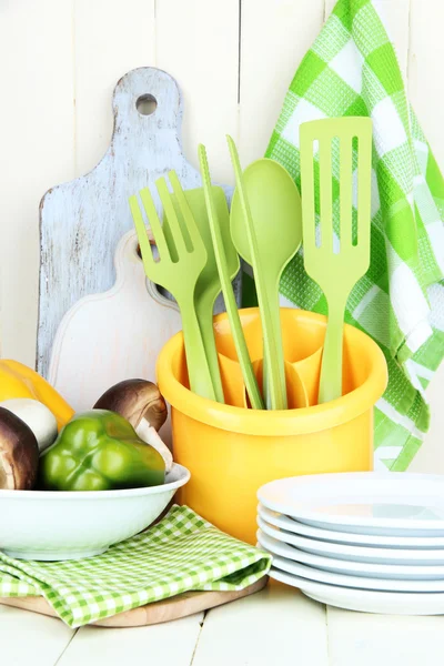 Utensili da cucina in plastica in tazza su tavolo di legno — Foto Stock