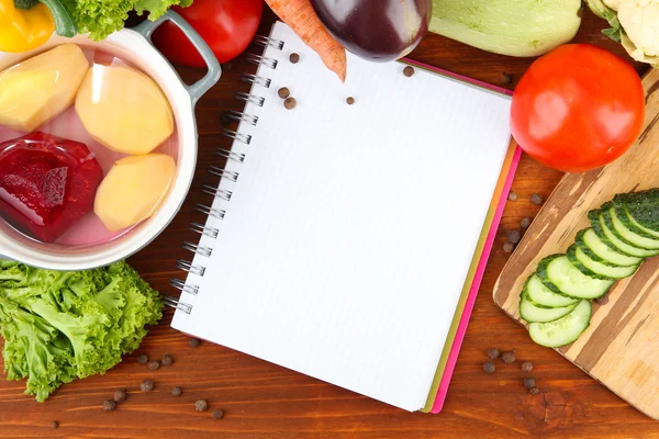 Fresh vegetables and spices and paper for notes, on wooden background — Stock Photo, Image