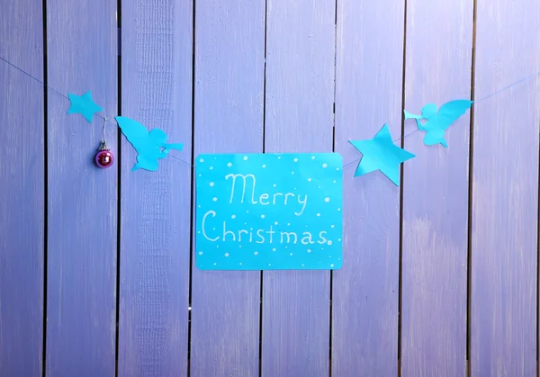 Bord met woorden vrolijk kerstfeest op houten tafel achtergrond close-up — Stockfoto