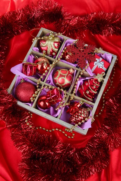 Brinquedos de Natal em caixa de madeira no fundo brilhante — Fotografia de Stock