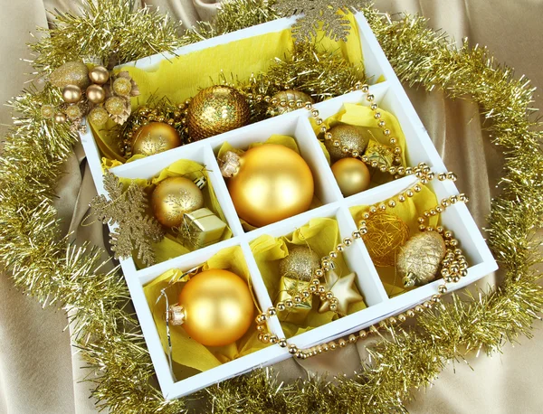 Brinquedos de Natal em caixa de madeira no fundo brilhante — Fotografia de Stock