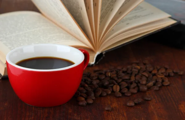 Xícara de café com grãos de café e livros sobre fundo de madeira — Fotografia de Stock