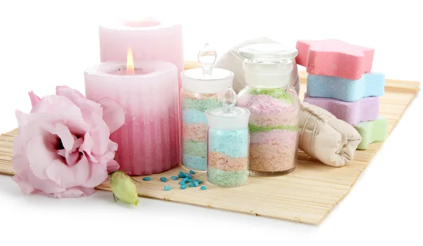 Sales aromáticas en frascos de vidrio y bolas de compresas de hierbas para el tratamiento de spa, sobre estera de bambú, aisladas en blanco — Foto de Stock