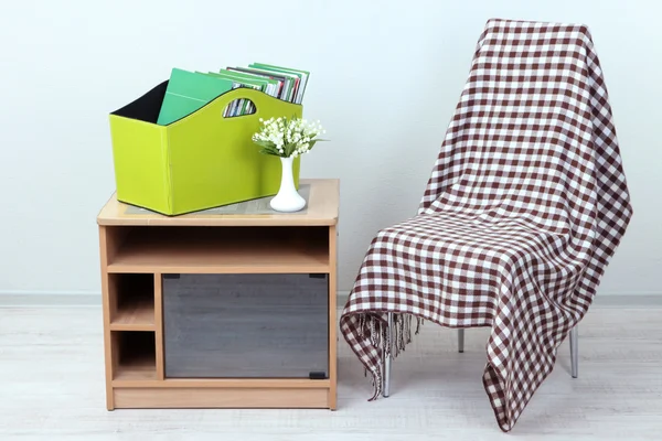 Magazines and folders in green box on bedside table in room — Stock Photo, Image