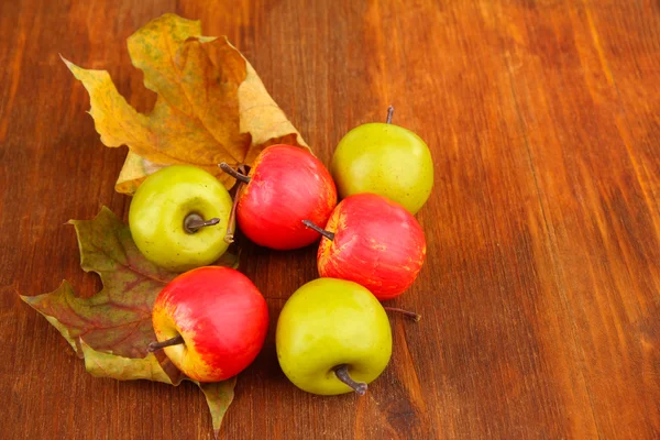 Small apples on wooden background — Stock Photo, Image