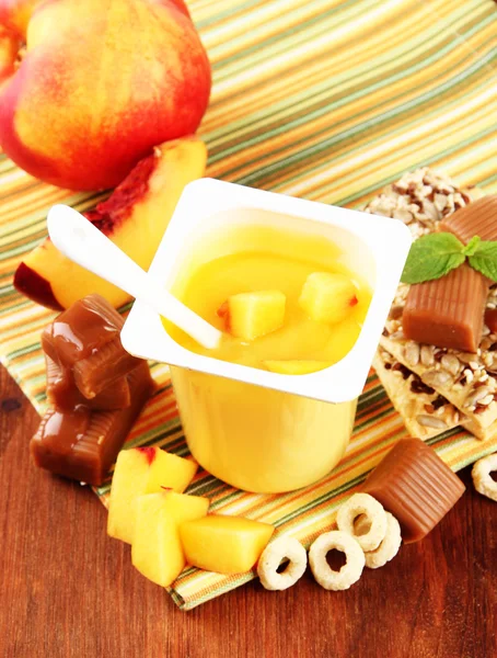 Вкусный йогурт со свежими фруктами, печеньем и хлопьями, на деревянном фоне — стоковое фото