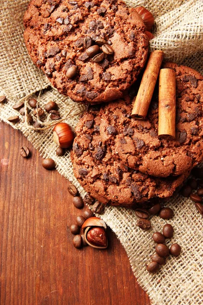 Homemade cookies with sesame seeds, chocolate, on wooden table, on sackcloth background — Stock Photo, Image