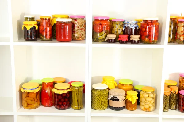 Different conservations on white shelves — Stock fotografie