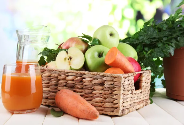 Manzanas dulces, zumo y zanahorias sobre mesa de madera sobre fondo natural —  Fotos de Stock