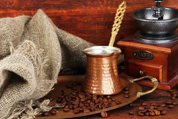 Kaffeemühle, Türkis und Kaffeebohnen auf goldenem Tablett auf Holzgrund — Stockfoto