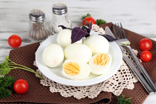 Œufs cuits dans une assiette sur une serviette sur une table en bois — Photo