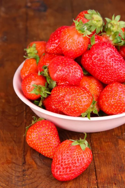 Fresh strawberry in bowl on wooden background — Stock Photo, Image