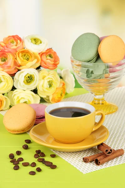 Kaffee und Makronen auf dem Tisch vor hellem Hintergrund — Stockfoto