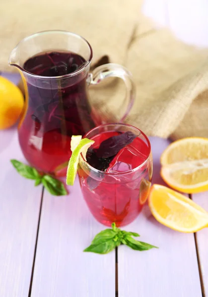 Kırmızı fesleğen limonata sürahi ve ahşap masa arka cam — Stok fotoğraf