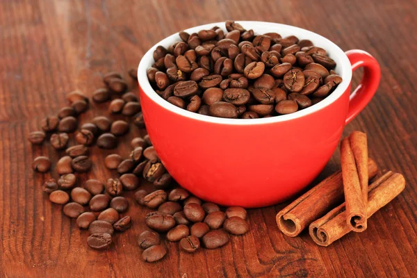 Zrnková káva v šálku na dřevěné pozadí — Stock fotografie