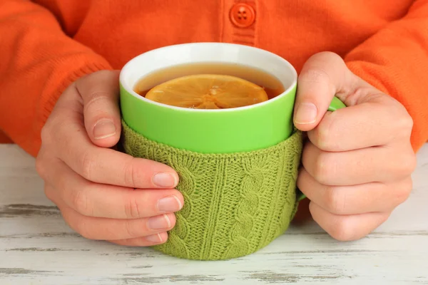 Cups with knitted things on it on wooden table close up — Stock Photo, Image