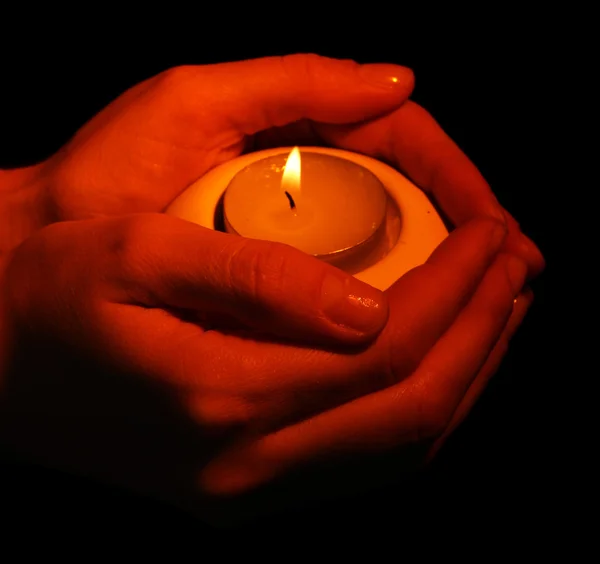 Bougie brûlante dans les mains isolées sur noir — Photo