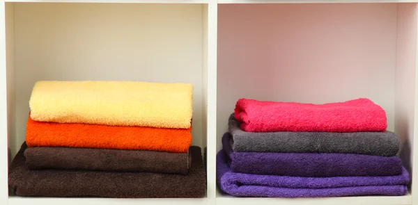 Яркие полотенца на полках — стоковое фото